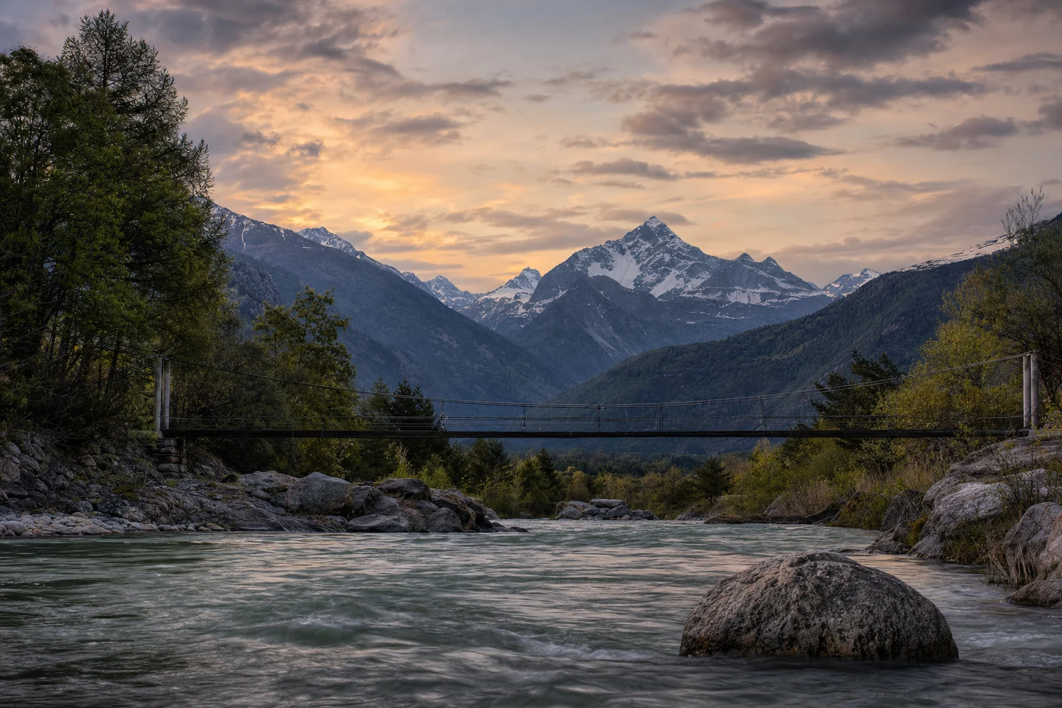 A suspension footbridge stretches over a calm mountain river with layered cliffs, soft light, and a wide cinematic natural landscape.